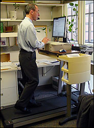 Dr. James Levine has a treadmill in place of a desk in his office, with a second one for visitors.
